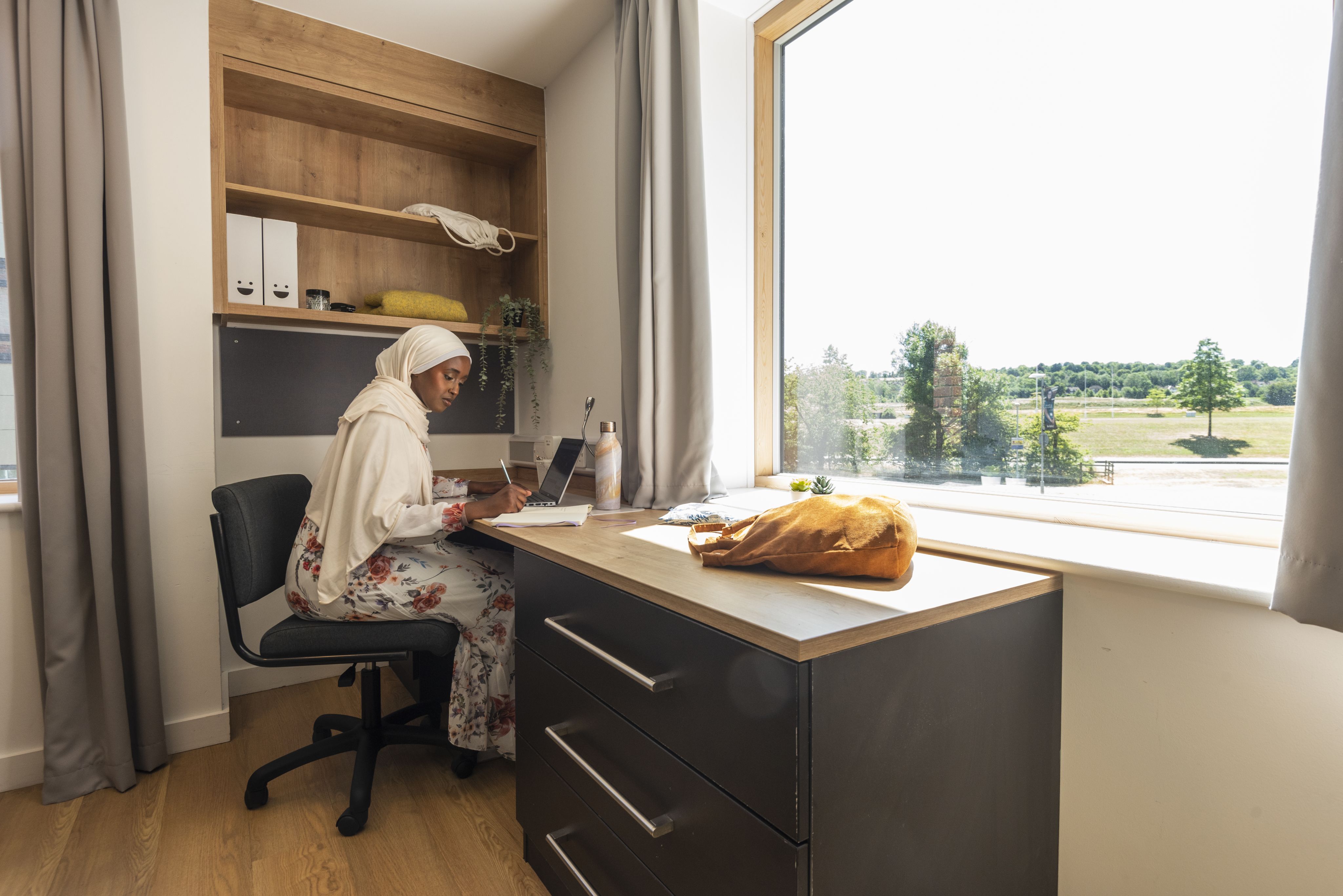 A female student sits at a desk overlooking Manor Park campus 