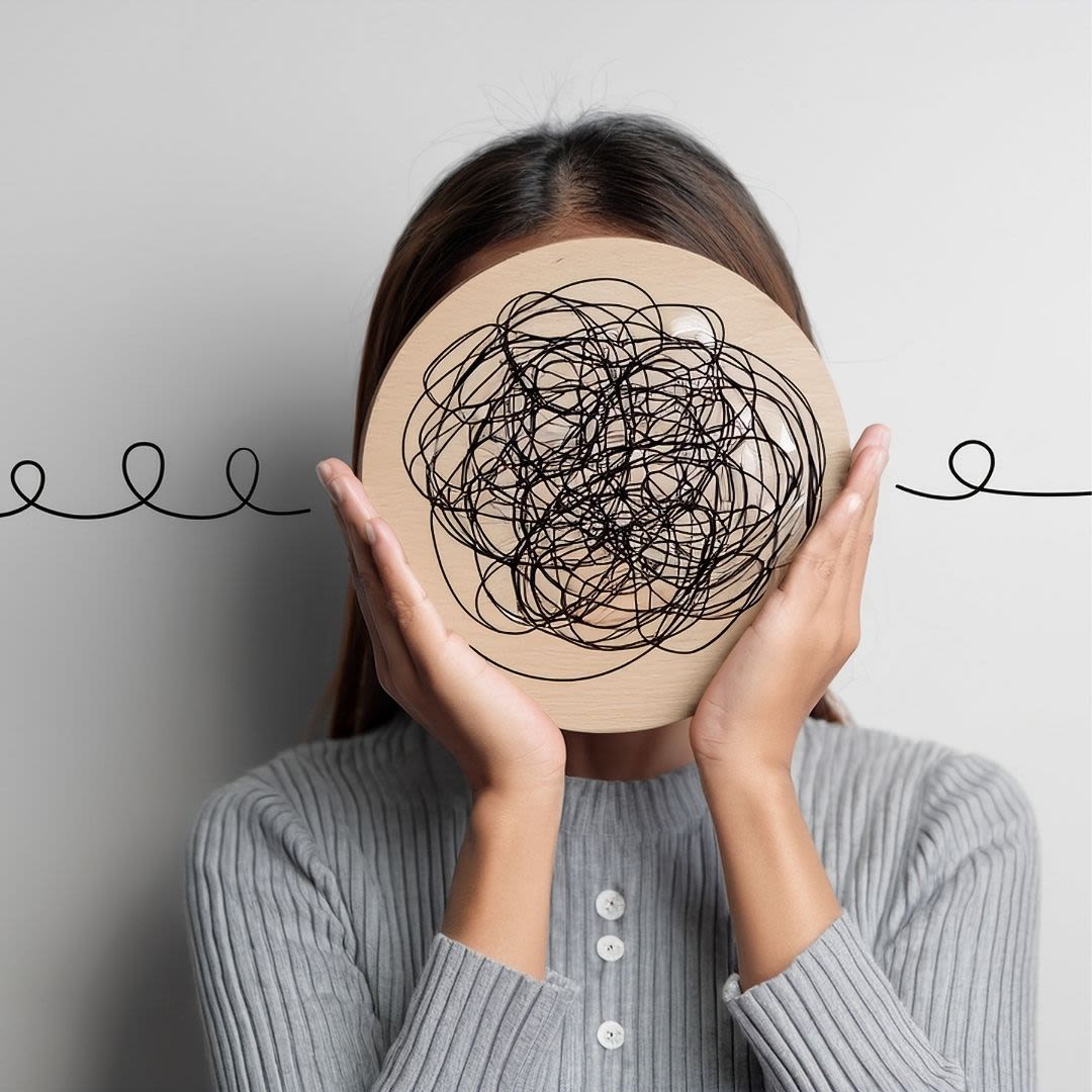 A female holds up a circular board in front of their face which is covered in squiggles