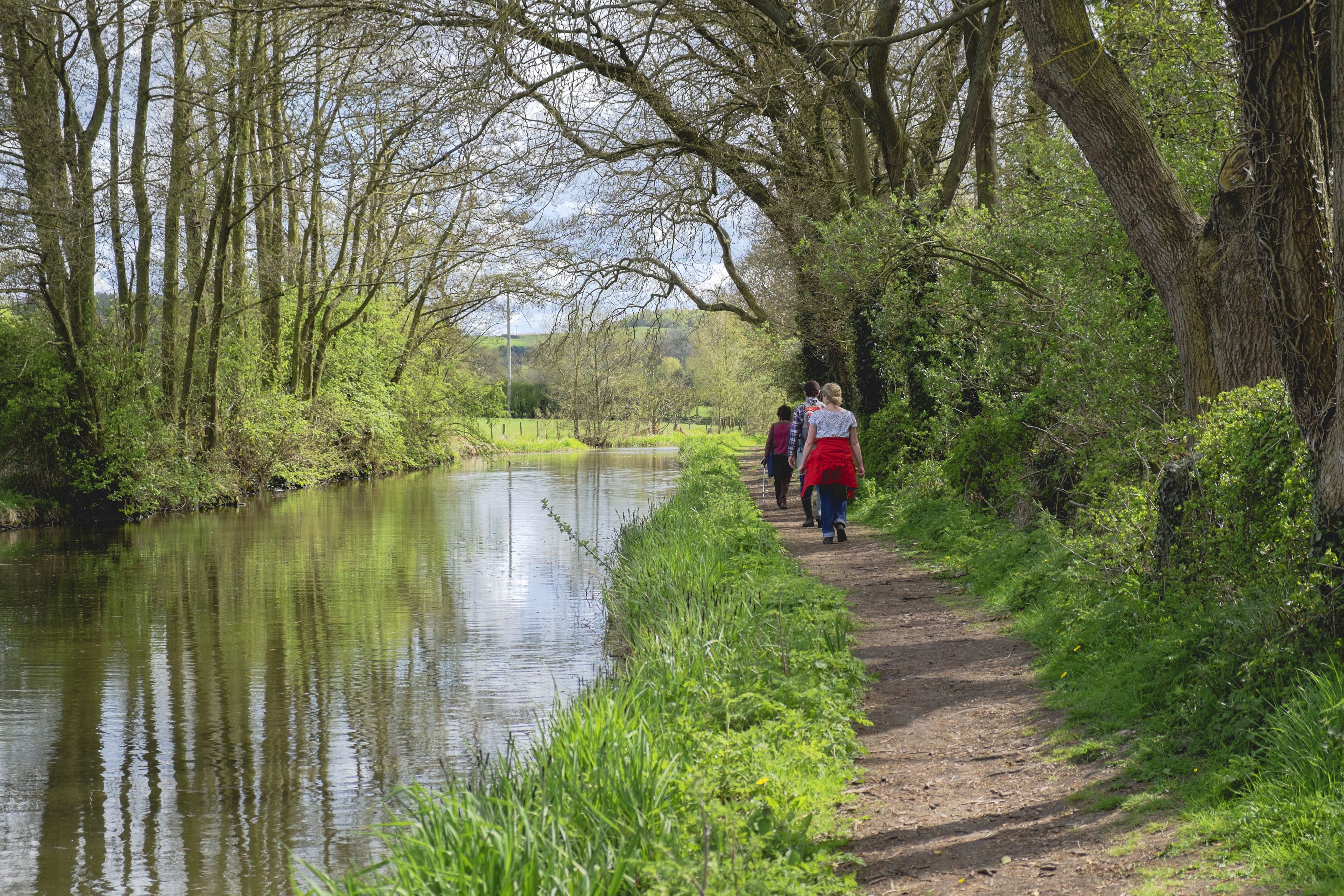 People walking on a path alongside a canal 