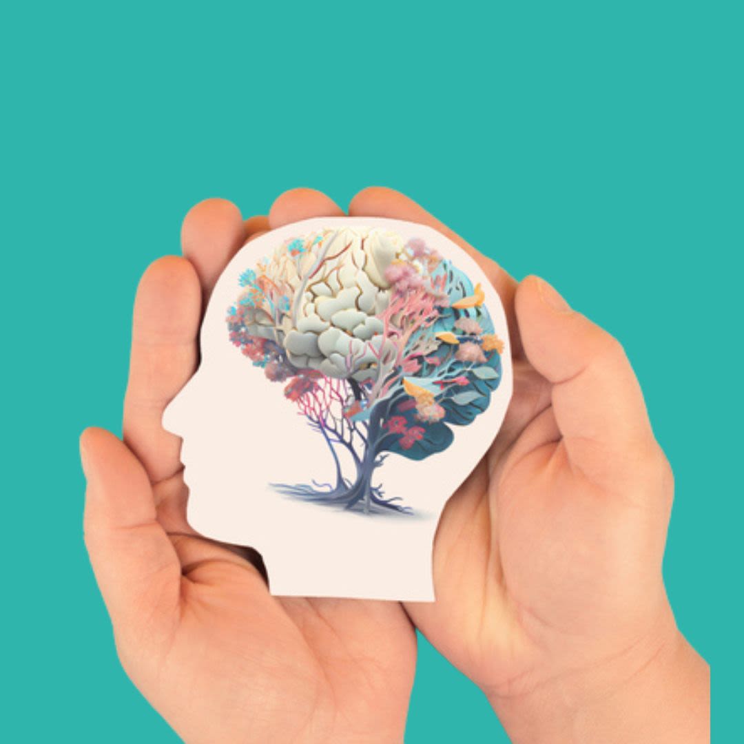 A pair of hands hold an outline of a silhoutte with the brain depicted as a tree in muted colours