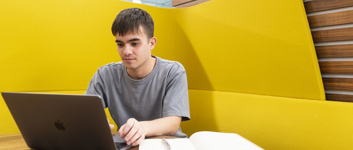Student working on campus with a laptop