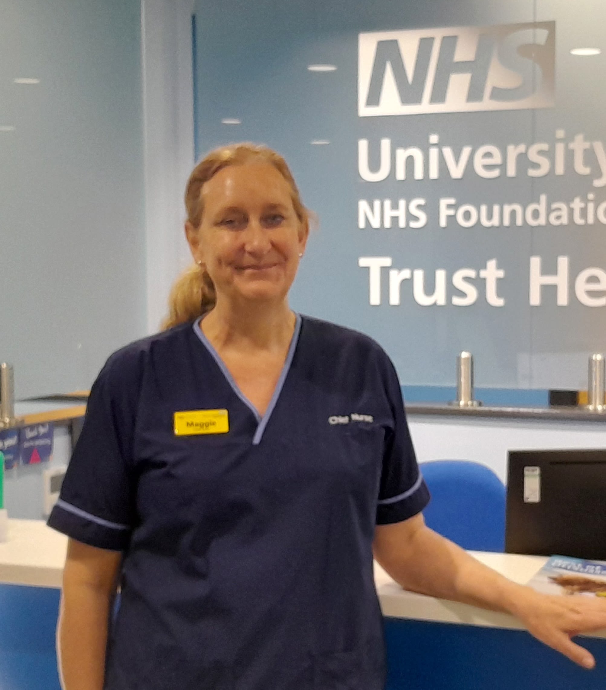 Dr Maggie Davies stands at the reception desk of her NHS trust headquarters