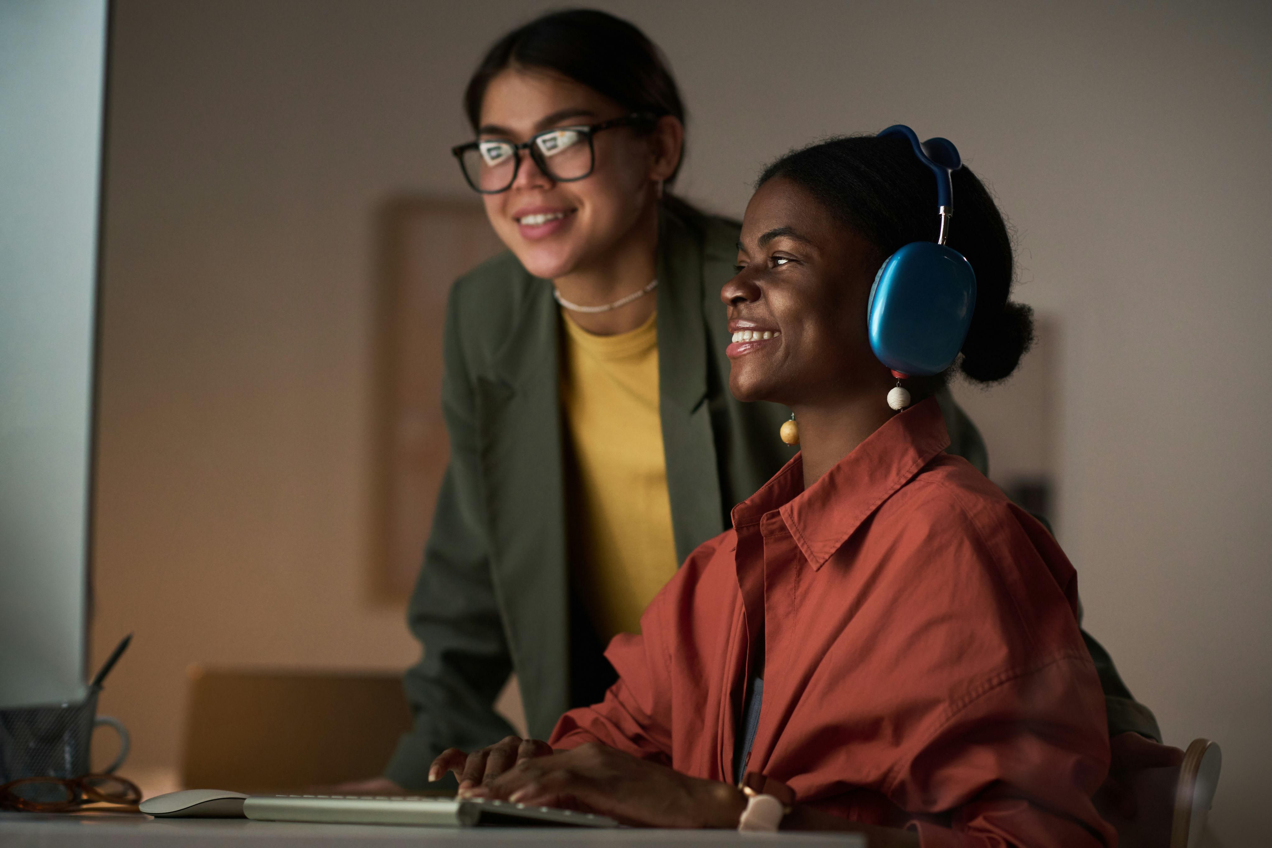 Two women work together at a computer.