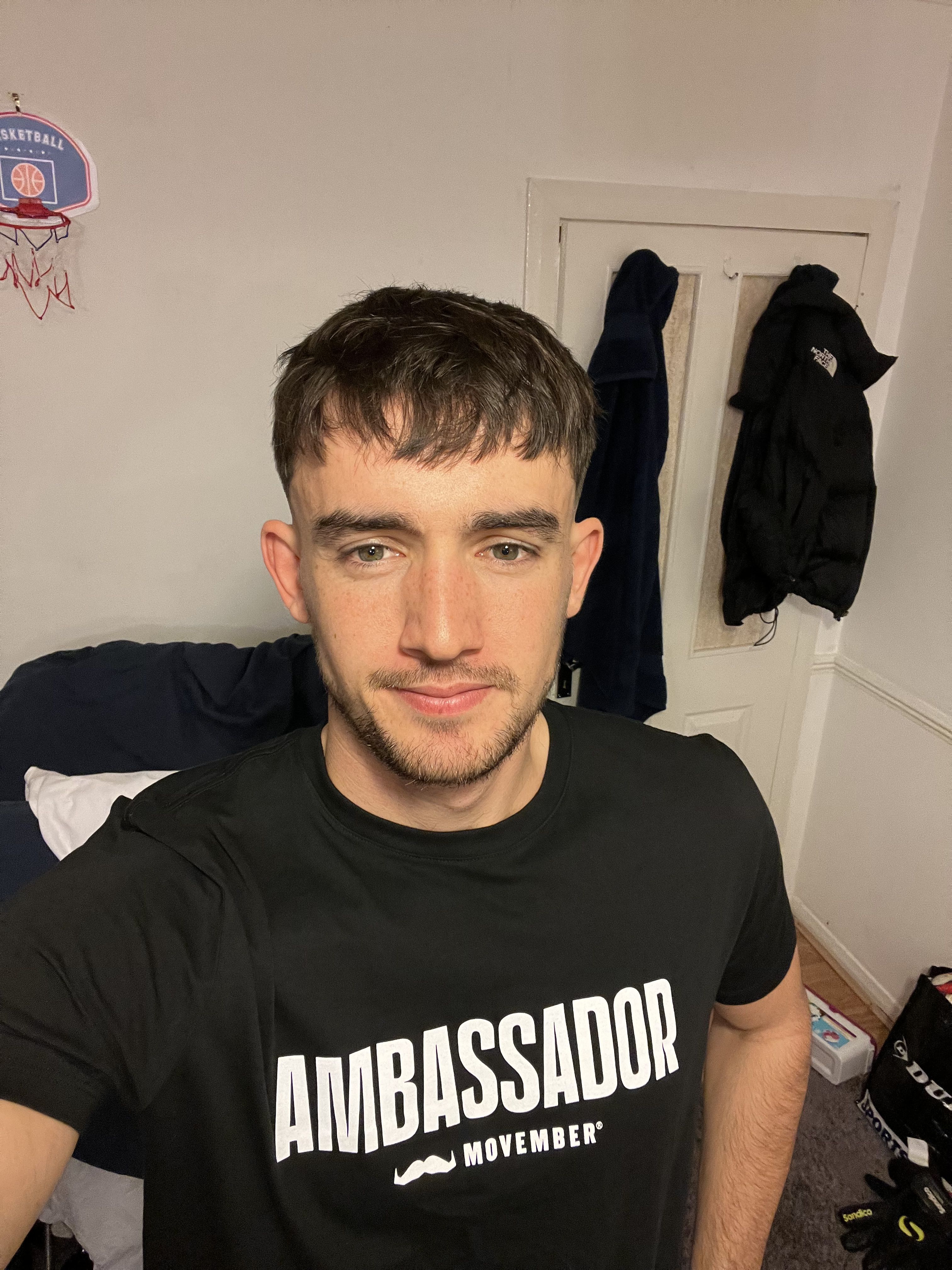 University of Surrey student Sam Head, sporting a moustache and wearing a Movember ambassador t-shirt