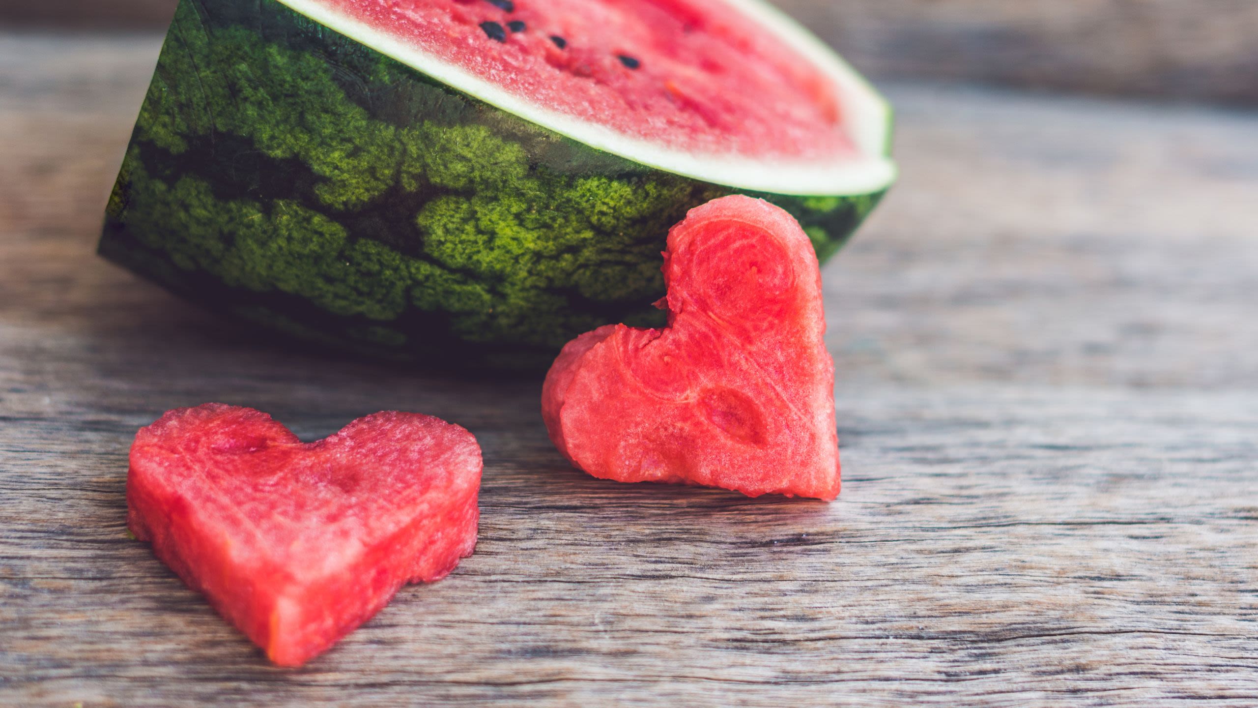 Two pieces of watermelon chopped in the shape of a heart