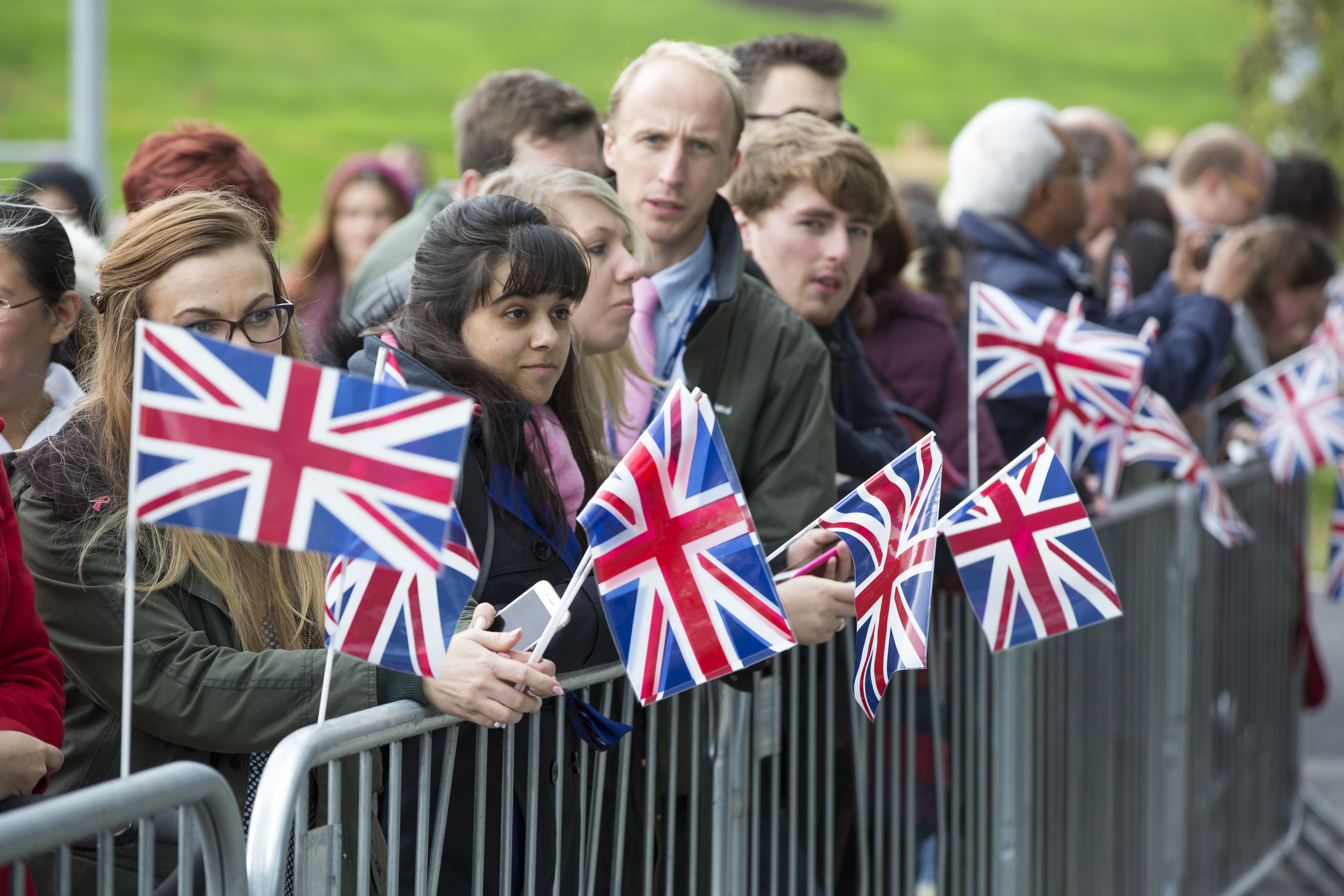 A crowd waiting to welcome The Queen. 