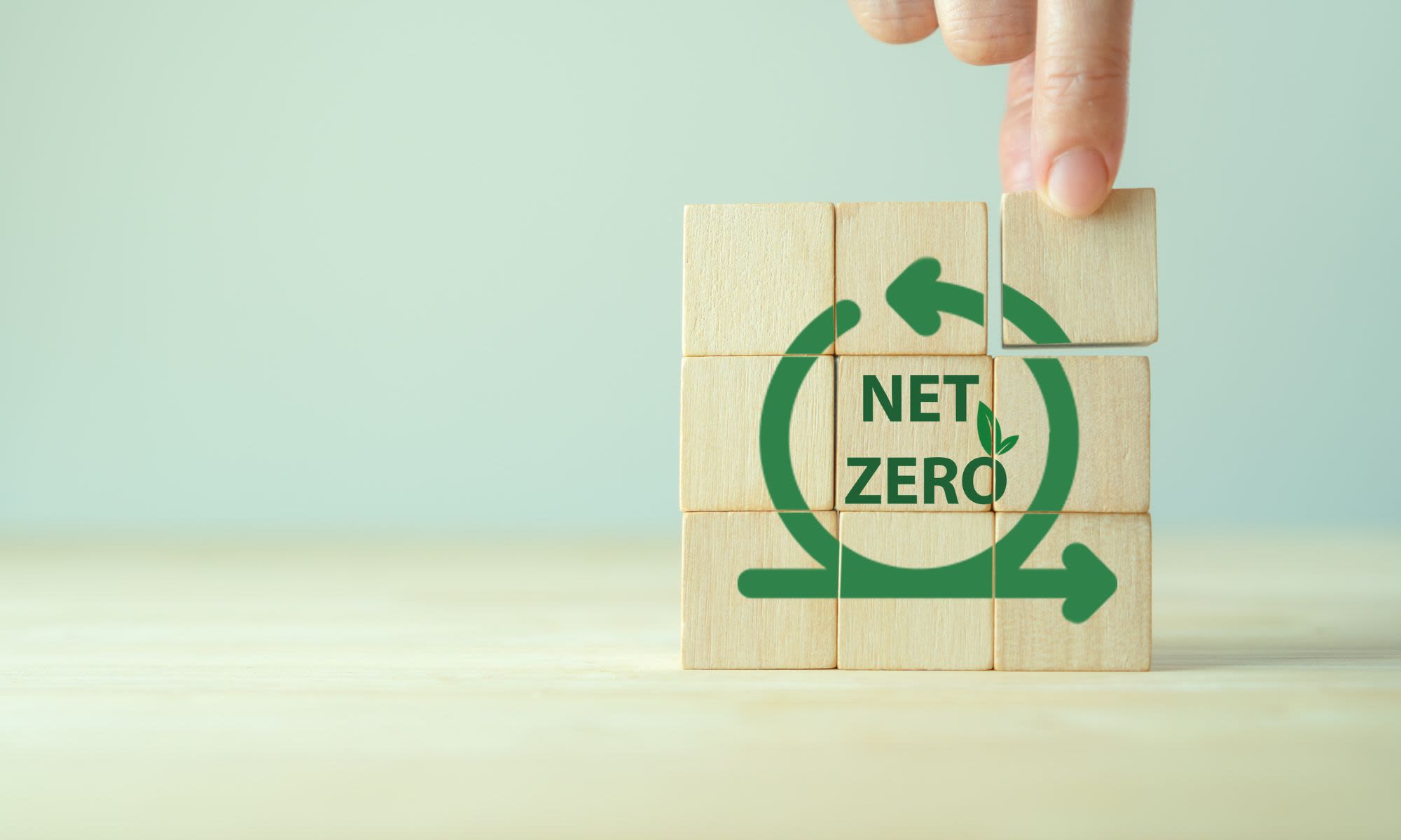 9 wooden cubes in a 3x3 formation spell out net zero in green