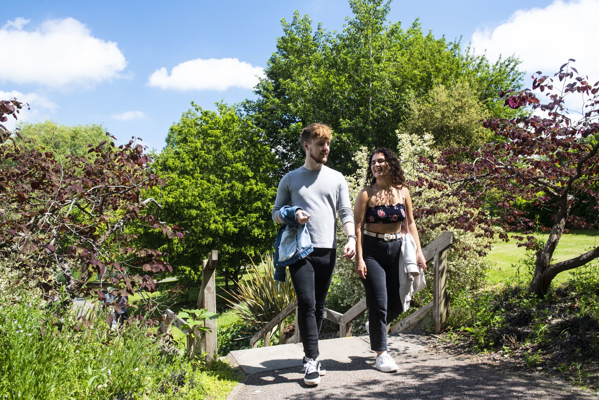 Two students walk by the lake on Stag Hill campus