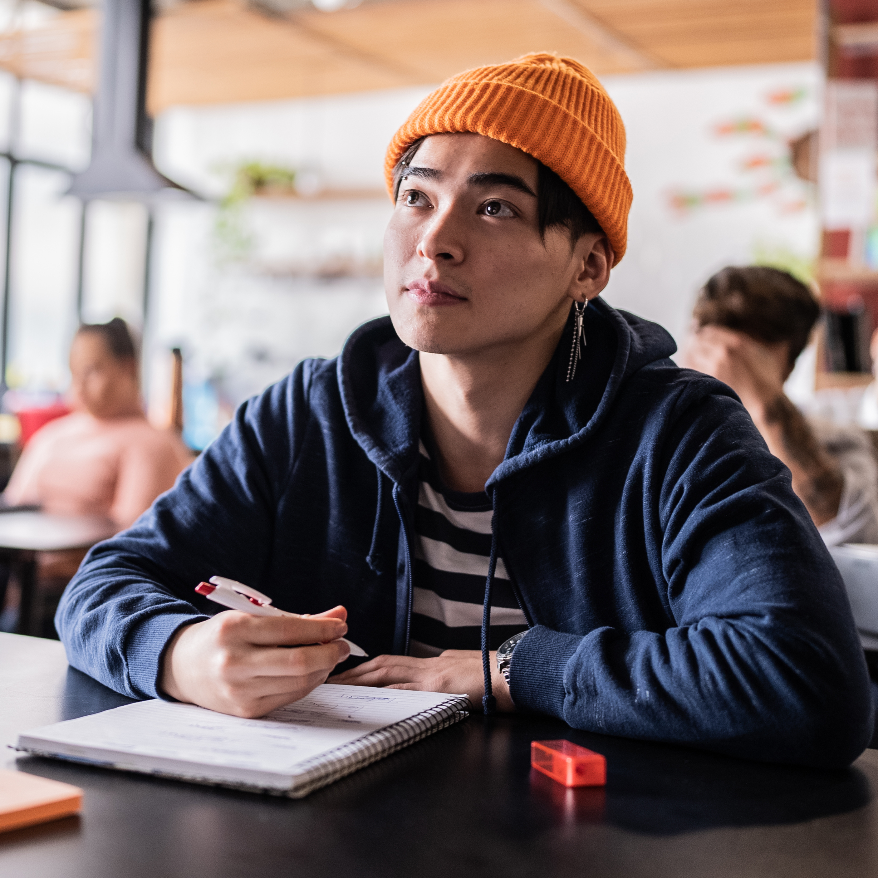 Student writing with a notebook and pen