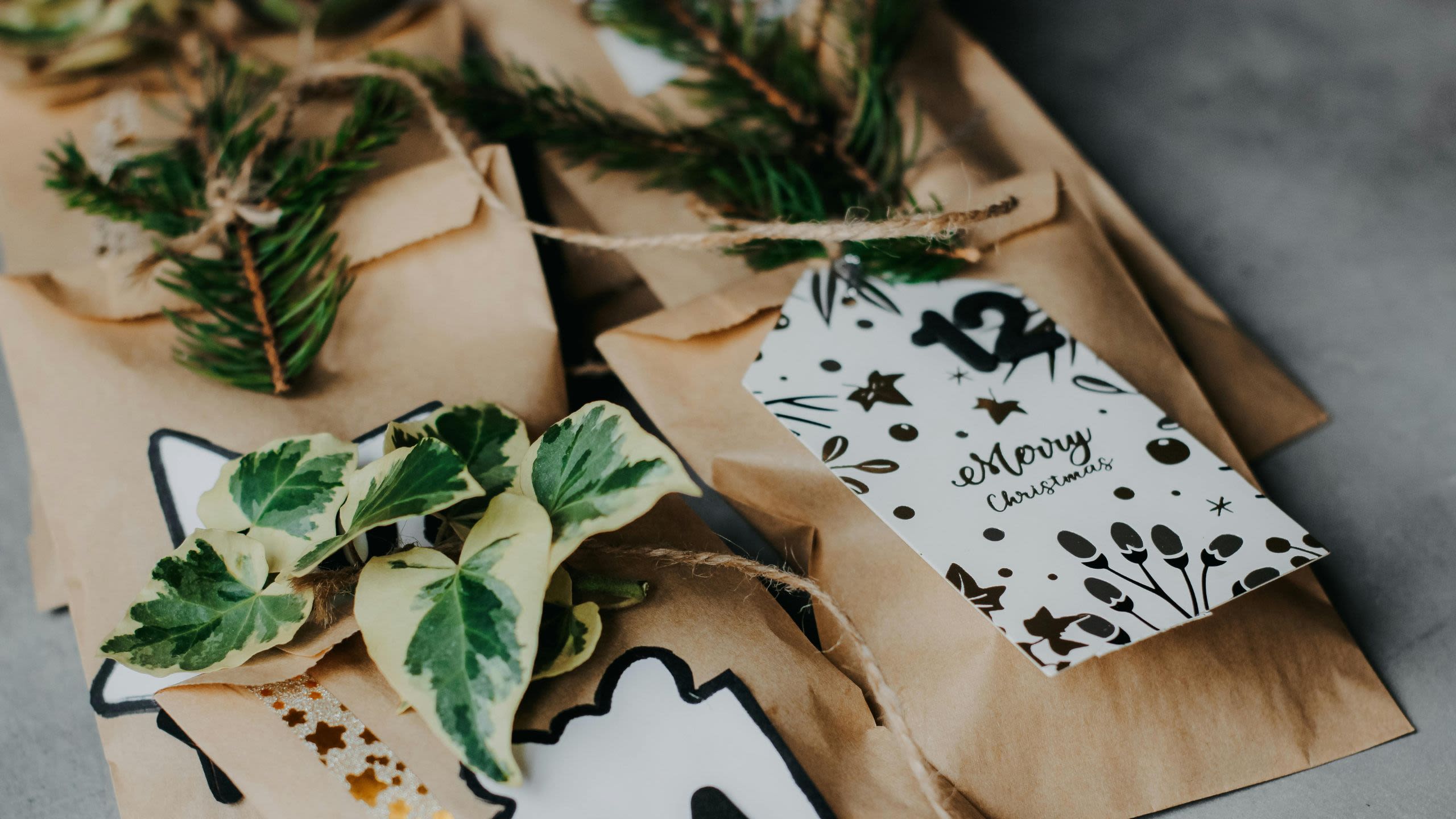 Paper bags decorated with Christmas tags and ivy leaves