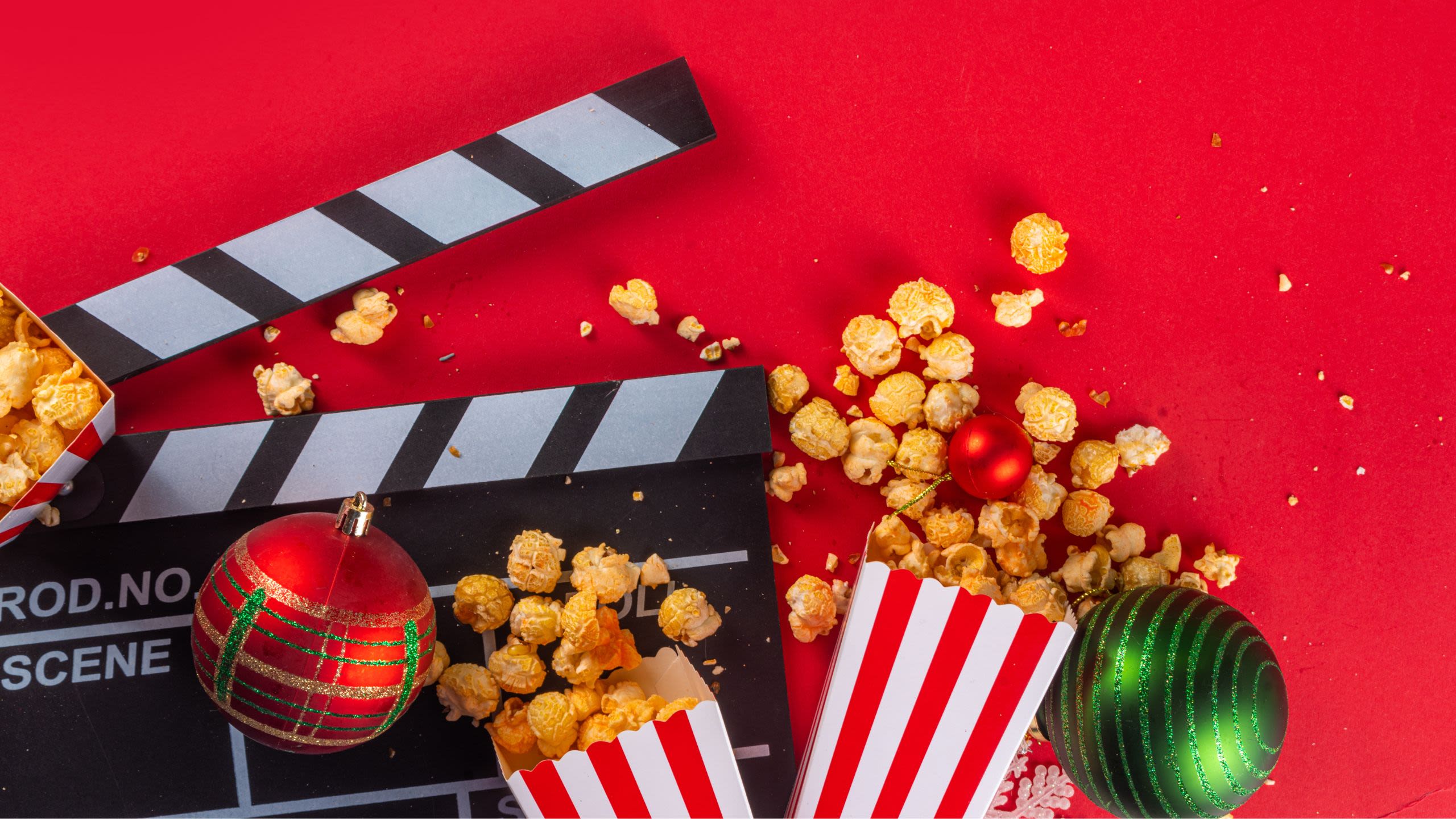 Flatlay of a clapper board with popcorn and Christmas baubles