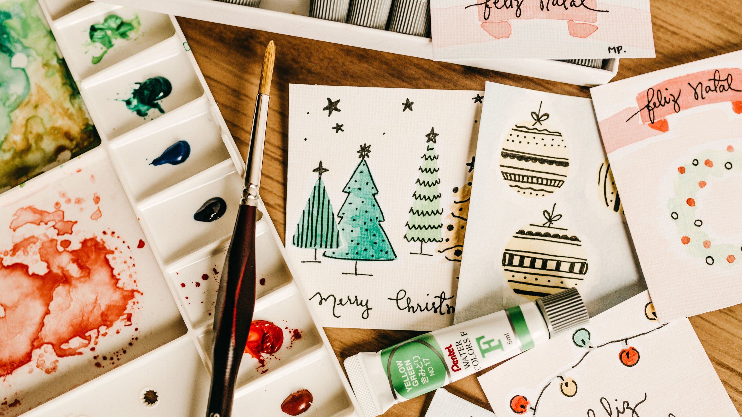 Homemade holiday cards with an easel, tube of green paint and paintbrush